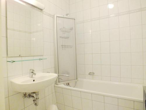 岑平Apartment Lotte的白色瓷砖浴室设有水槽和浴缸