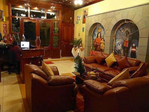 库斯科因卡伊拉酒店的客厅配有真皮沙发和钢琴