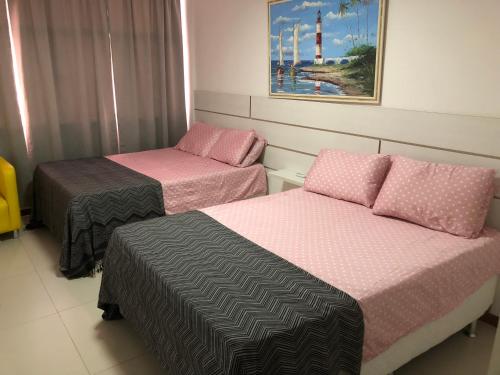 萨尔瓦多Luxury 3 Bedroom Apartment - Barra的一间设有两张床的客房,墙上挂着一幅画