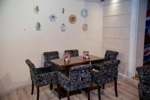 Loutrópolis ThermísPalataki Studios的餐桌和椅子,墙上挂有盘子
