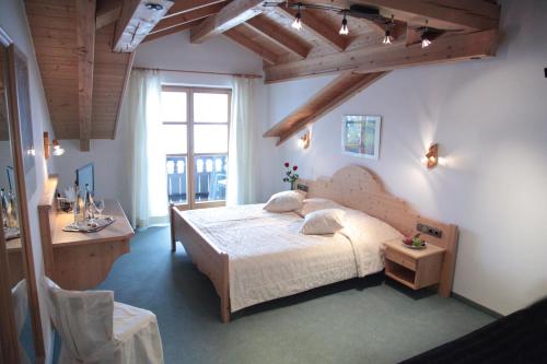 里姆斯廷格Hotel Garni Georgenhof Adults Only的一间卧室配有一张床、一张书桌和一个窗户。