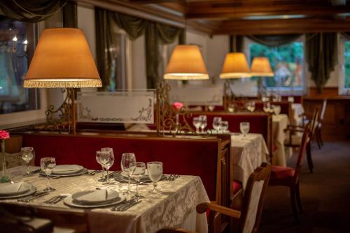 格拉玛多里塔霍普纳酒店的餐厅设有桌子、酒杯和灯具