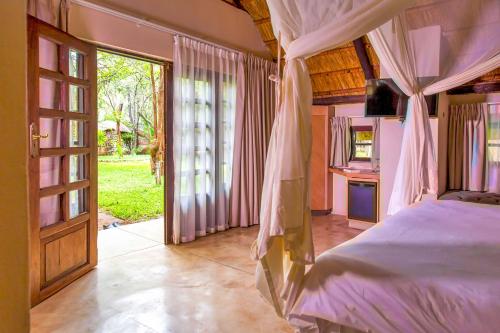 利文斯顿The Royal Sichango Village的一间卧室设有一张床和一个开放式门