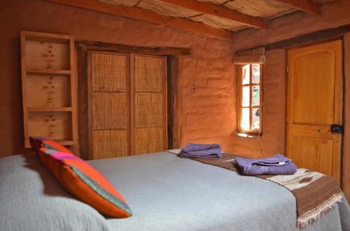 圣佩德罗·德·阿塔卡马Ckuri Atacama的一间卧室配有一张床,上面有两条毛巾
