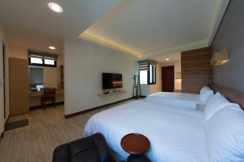 台东一品苑民宿的酒店客房设有两张床和电视。