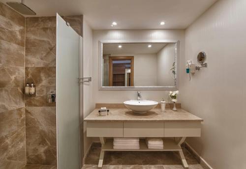欧库卡拉Botanik Hotel的一间带水槽和镜子的浴室