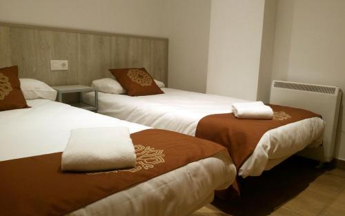 塞拉内华达Apartamentos Sabica Nevada Plaza的酒店客房,配有两张带棕色和白色毯子的床