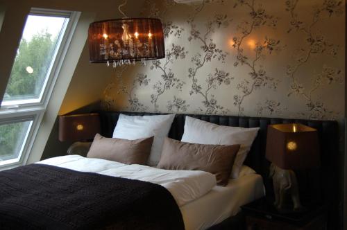 埃森Boutique-Hotel GEORGES的一间卧室配有一张床和一个吊灯