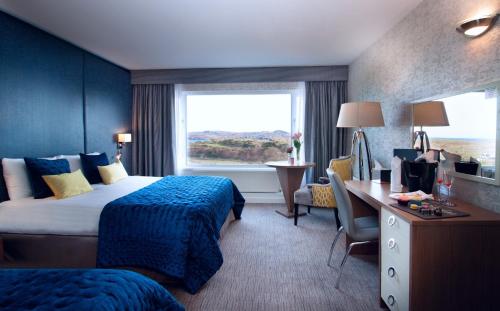 邓法纳希Shandon Hotel & Spa的酒店客房设有两张床、一张书桌和一个窗户。
