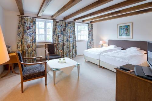 贝尔吉施格拉德巴赫曼戈尔德罗曼蒂克瓦尔德酒店的酒店客房设有一张床、一张书桌和一台电视机。