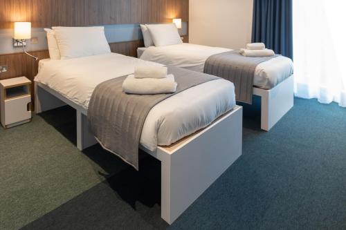 拉夫堡Elite Athlete Centre and Hotel的酒店客房,配有两张带毛巾的床