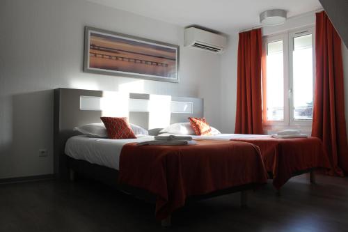 苏斯通Hôtel du Centre的一间卧室配有两张红色窗帘