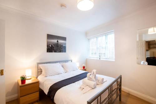 斯丹斯达蒙费雪特Spacious 2BR Flat in Stansted的一间卧室配有一张床,上面有两条毛巾
