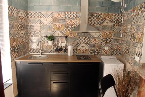 米哈斯拉波萨达旅馆的小厨房配有水槽和瓷砖墙壁