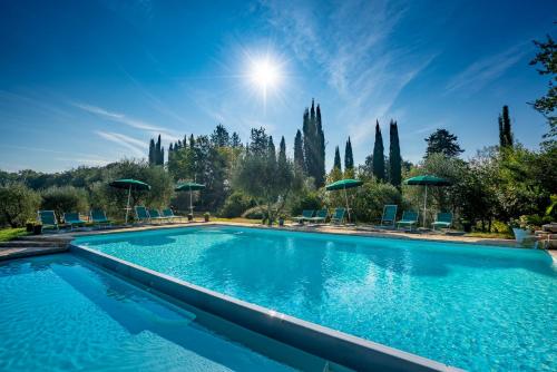圣吉米纳诺托雷西亚睇楚思农舍酒店的一个带蓝色椅子和遮阳伞的游泳池
