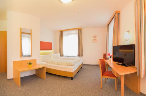 因斯布鲁克斯特凡布科宾馆酒店的酒店客房设有一张床、一张书桌和一台电视机。