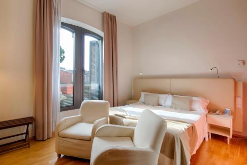 卡尔德斯德马拉维亚普拉茨水疗酒店的卧室配有床、椅子和窗户。