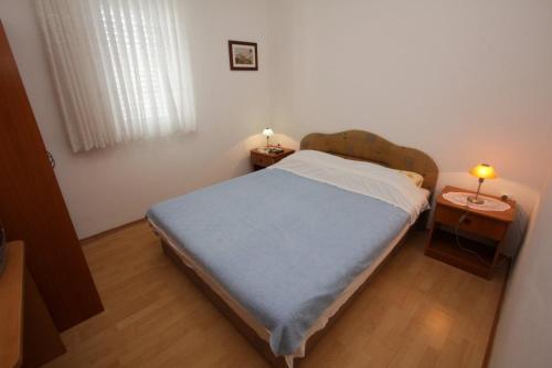 波弗加纳Apartments Bresina的一间小卧室,配有一张床和两张桌子