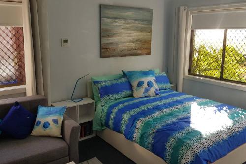 悉尼Seadreams, Maroubra的一间卧室配有一张床、一张沙发和一个窗口