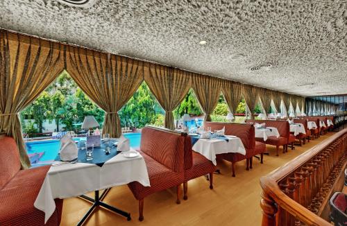 钦奈帕拉瓦大使酒店的一间带桌椅的餐厅和一个游泳池