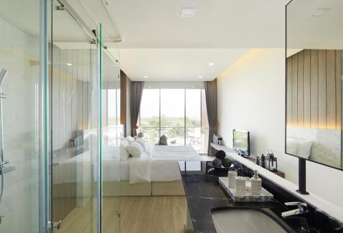 北标府Phurinda Residence的浴室设有床铺和玻璃淋浴间。