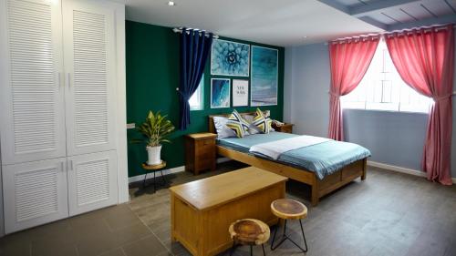 富国Sleep Box Hostel Phú Quốc的一间卧室设有一张床和绿色的墙壁