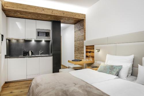 伊施格尔阿尔品拉提亚公寓的一间带白色床的卧室和一间厨房