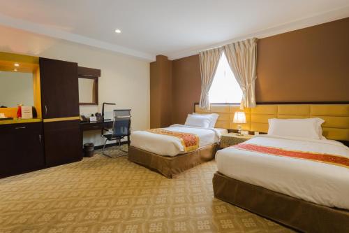 马六甲霍尔马克皇冠酒店的酒店客房配有两张床和一张书桌