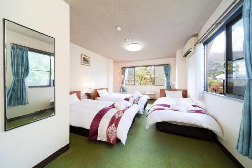 白马村P-鲍贝提酒店的带窗户的客房内的三张床