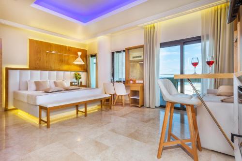 帕拉塔蒙Porto Marine Hotel的一间卧室配有一张床和一张带酒杯的桌子