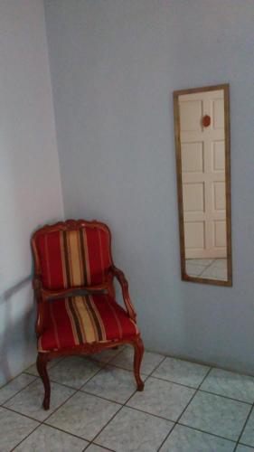 圣伊格纳西奥Don Santiago Guesthouse Downtown的一张红色椅子,坐在一个带镜子的房间