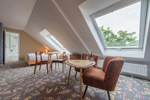 黑尔戈兰岛克拉西克公寓的客房设有2张桌子和椅子以及窗户。