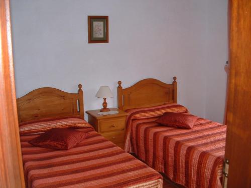 丰卡连特德拉帕尔马Casa Los Viñedos B的一间卧室设有两张床和一张桌子上的台灯。