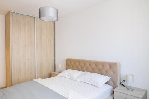 布拉索夫Apartament 4Tourists 2的卧室配有白色的床和灯具