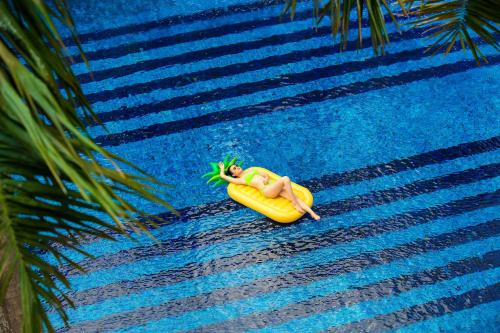 顺化印度希纳宫殿酒店的躺在游泳池香蕉上的女人