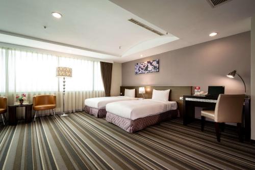嘉义市嘉义优遊商旅的酒店客房配有两张床和一张书桌