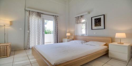撒尼海滩Ekatis Houses的一间卧室设有一张大床和一个窗户。
