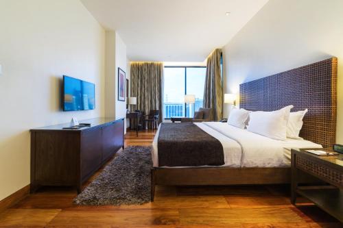 马尼拉City Garden Grand Hotel的酒店客房设有一张床和一个大窗户