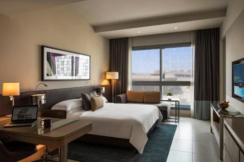 阿布扎比首都中心罗塔纳公寓式酒店的大型酒店客房,配有床和沙发