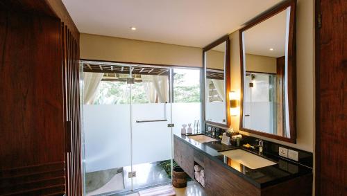 乌布Tejaprana Resort & Spa的一间带两个盥洗盆和大镜子的浴室
