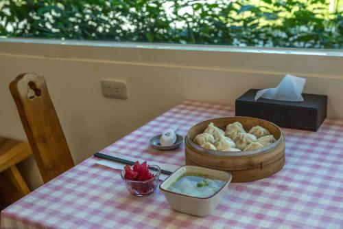 Pinghe元气屋民宿的一张桌子,上面放着一碗食物和一碗面包