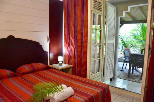哥西尔Résidence Turquoise Guadeloupe - Vue mer et lagon的一间卧室设有一张床,并有通往庭院的门