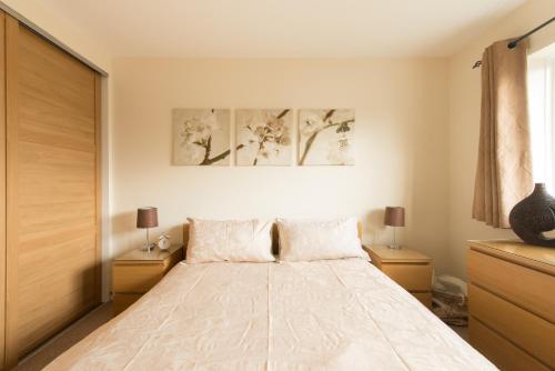 格洛斯特切斯特顿苑公寓的一间卧室配有一张带2个床头柜的大床
