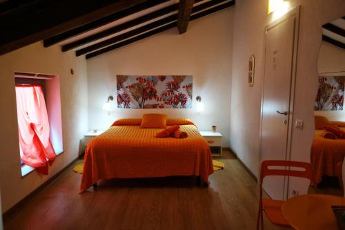 斯培西亚我之色彩小屋的一间卧室配有两张带橙色床单的床