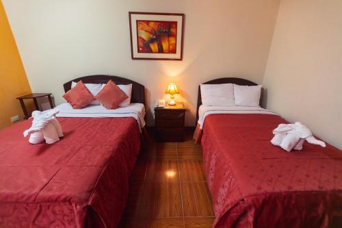 特鲁希略Hotel Plaza Trujillo的两张位于酒店客房的床,配有毛巾