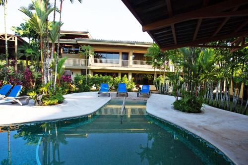 福尔图纳阿雷纳背包客度假村旅馆的一座游泳池旁设有两把蓝色椅子