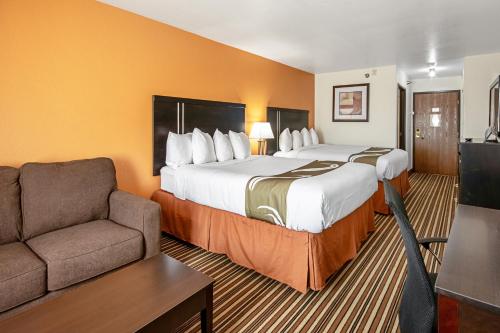 道奇城Quality Inn Dodge City的酒店客房,设有两张床和一张沙发