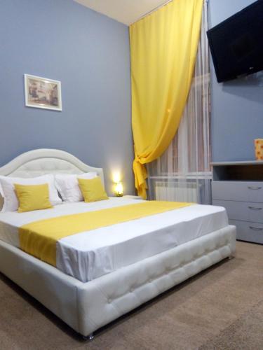 利沃夫Near Rynok Square的一间卧室配有一张黄色窗帘的大床