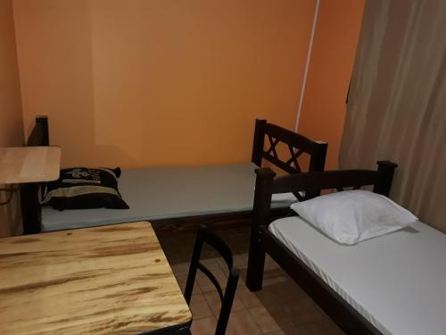 圣何塞Hotel Latino的配有床、桌子和椅子的房间