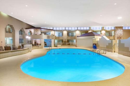 格兰德岛Ramada by Wyndham Midtown Grand Island的酒店大堂中央的大型游泳池